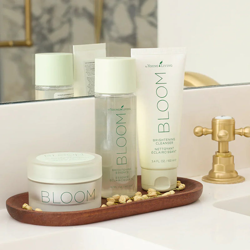 Bottle of Bloom Brightening Cleanser with flowers and plant background